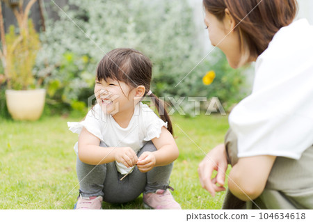Photo of a parent and child playing in the garden 104634618