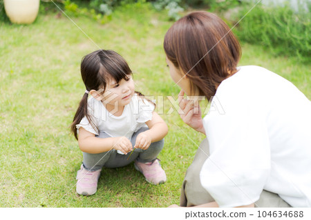 Photo of a parent and child playing in the garden Photo of a parent and child playing in the garden 104634688
