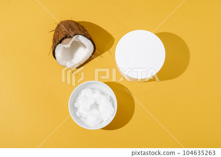Half a coconut, coconut oil and a jar of coconut cream on a yellow background. Half a coconut, coconut oil and a jar of coconut cream on a yellow background. 104635263