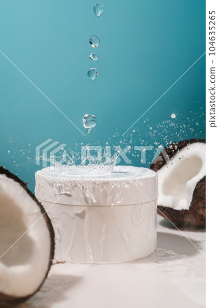 Two halves of coconut and a jar of cosmetics on a blue background with water drops. Two halves of coconut and a jar of cosmetics on a blue background with water drops. 104635265