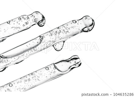Three transparent pipettes with cosmetics on a light background. 104635286