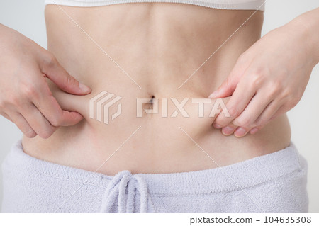 Squeezing the belly fat Slimming the stomach 104635308