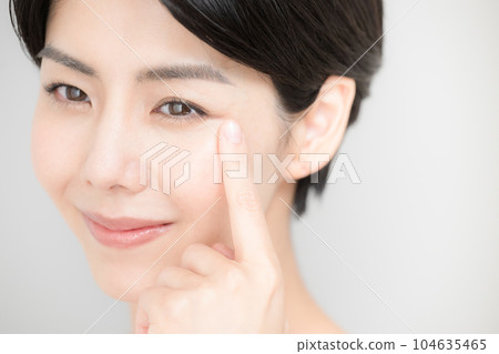 Close-up of a woman pointing to eyelashes and eyes that are easy to use for beauty Close-up of a woman pointing to eyelashes and eyes that are easy to use for beauty 104635465