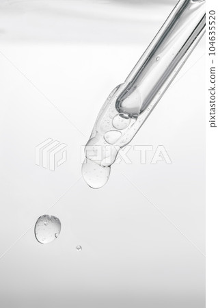 Pipette with cosmetic product in water with bubbles. 104635520