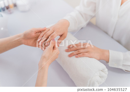 美甲師和女性在美甲沙龍諮詢雙手 美甲師和女性在美甲沙龍諮詢雙手 104635527
