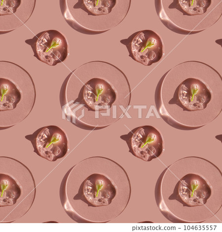 A drop of cosmetic gel with a flower on a pink background. A drop of cosmetic gel with a flower on a pink background. 104635557