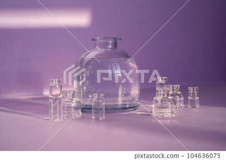 Beautiful abstract background with glass containers on a purple background. 104636075