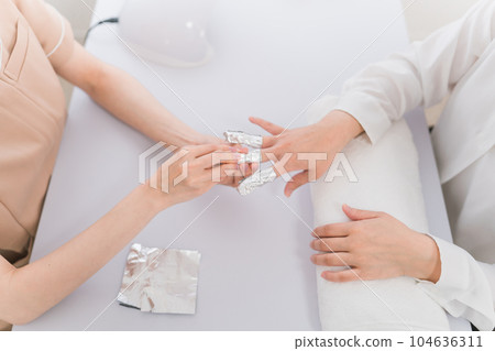 美甲師和亞洲婦女在美甲沙龍用丙酮去除指甲 104636311