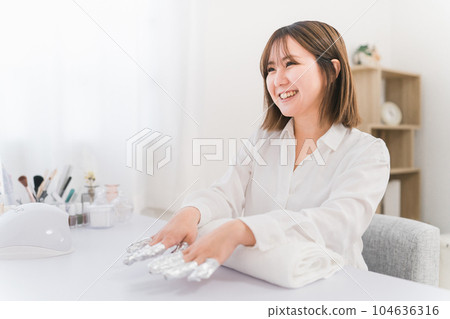 Manicurist and Asian woman removing nails with acetone at nail salon Manicurist and Asian woman removing nails with acetone at nail salon 104636316