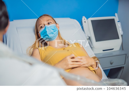 In the Hospital, Close-up Shot of the Doctor does Ultrasound Sonogram Procedure to a Pregnant Woman. Obstetrician Moving Transducer on the Belly of the Future Mother 104636345