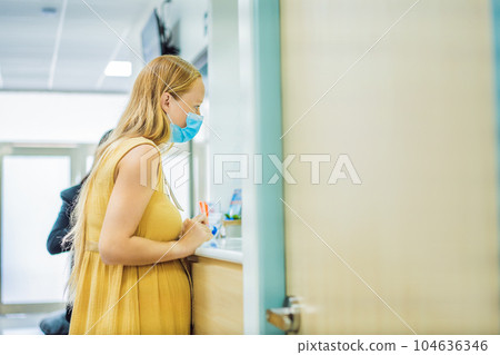 young woman in the waiting room interview sitting on sofa in corridor of dentist office or reception modern medical center while doctor's appointment. using mobile phone fills information or resumes 104636346