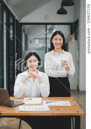 Happy business woman standing competently and smiling in open plan office with blurry collea gues sitting in office as background, Business concept. Happy business woman standing competently and smiling in open plan office with blurry collea gues sitting in office as background, Business concept. 104637159
