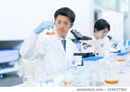 Researcher doing an experiment in a laboratory Researcher doing an experiment in a laboratory 104637962