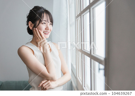 一個女人在窗口觸摸她的皮膚（美容、皮膚護理、基本化妝品圖像） 104639267
