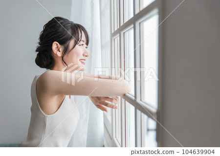 Asian woman waking up and opening the curtains in the morning sun, smiling asian woman 104639904
