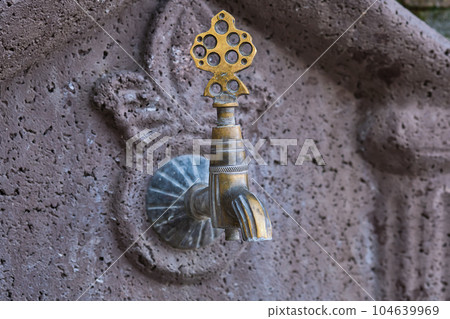 Old copper faucet in a public place on the street of the old city in Turkey, travel time, idea for background 104639969