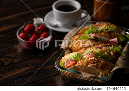 Sandwich With hot coffee Egg, cheese, ham, baguette sandwich with plenty of vegetables Sandwich With hot coffee Egg, cheese, ham, baguette sandwich with plenty of vegetables 104640623