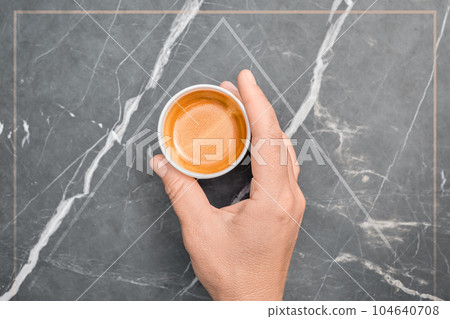 Poster or advertising concept, female hand holding a cup of hot espresso coffee in a paper cup, the cup is isolated in a gray frame, coffee break, free space for text Poster or advertising concept, female hand holding a cup of hot espresso coffee in a paper cup, the cup is isolated in a gray frame, coffee break, free space for text 104640708