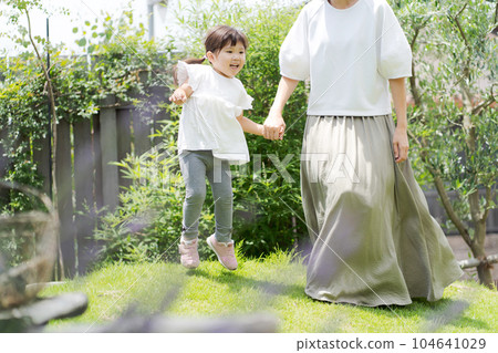 Image of mother and girl playing in the garden 104641029