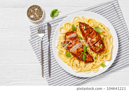 crusted chicken over lemon butter pasta, top view crusted chicken over lemon butter pasta, top view 104641221