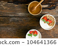 Strawberry yogurt in a wooden bowl with granola, mint and fresh strawberry on wooden background. Health food concept 104641366
