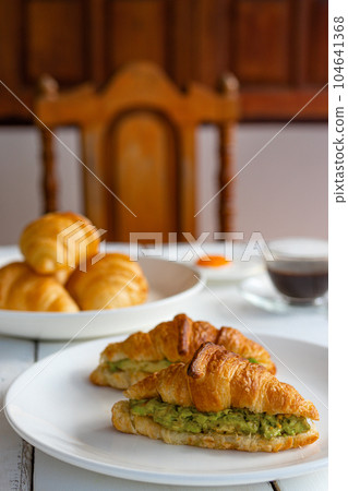 Croissant sandwich with egg,avocado on white dish and honey, coffee. breakfast and healthy food concept.. 104641368