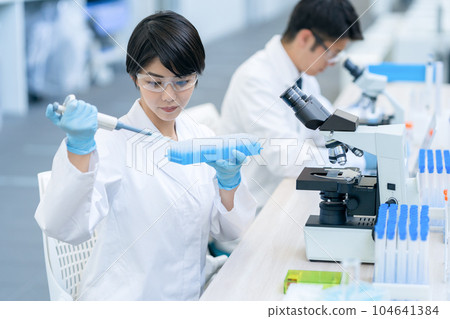 Researcher doing an experiment in a laboratory Researcher doing an experiment in a laboratory 104641384