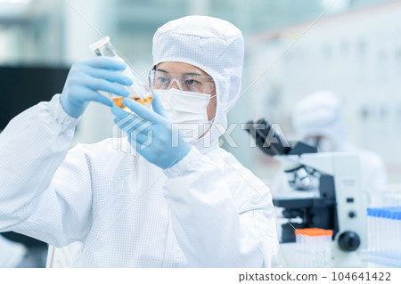 A researcher conducting an experiment in a clean room 104641422