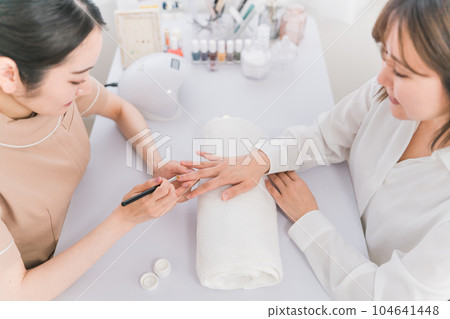 美甲師和在美甲沙龍塗底漆的女性 美甲師和在美甲沙龍塗底漆的女性 104641448