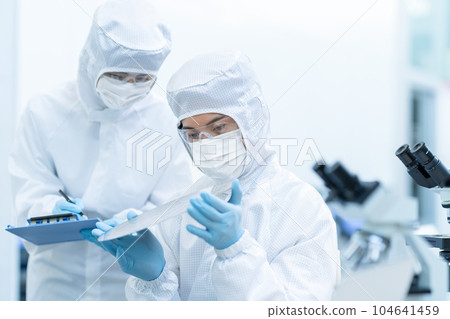 Engineer inspecting wafers in clean room 104641459