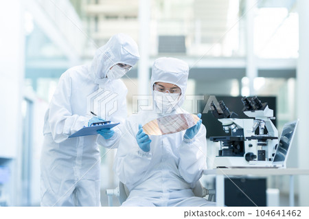Engineer inspecting wafers in clean room Engineer inspecting wafers in clean room 104641462