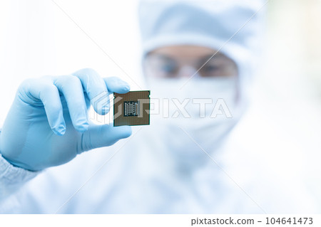 Engineer inspecting CPU in clean room 104641473