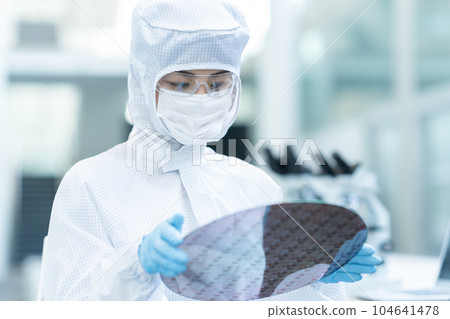 工程師在潔淨室檢查晶圓 104641478