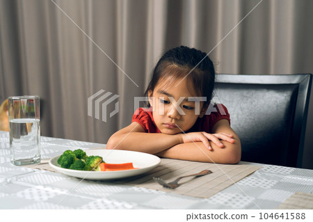 Little cute kid girl refusing to eat healthy vegetables. Children do not like to eat vegetables. 104641588