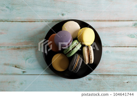 Colorful macaron cookies on black color plate. Sweet and colorful French macarons. 104641744