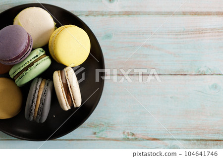 Colorful macaron cookies on black color plate. Sweet and colorful French macarons. 104641746