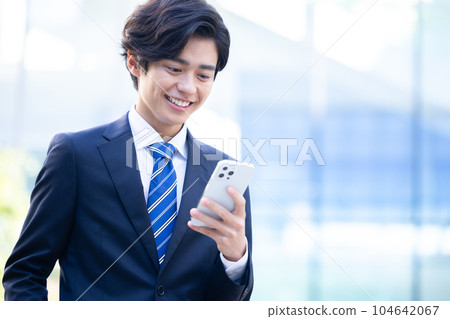 A young man looking at a business smartphone Photographing cooperation "LINK FOREST" 104642067