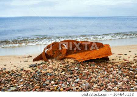 A rusty metal fragment of a ship's side thrown onto the seashore A rusty metal fragment of a ship's side thrown onto the seashore 104643138