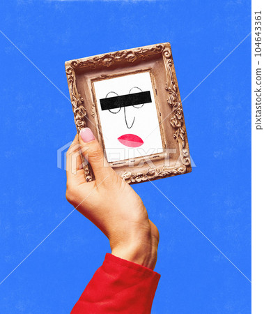 Female hand holding small mirror with drawn facial expression over blue background. Doodles, sketches, cartoon drawing style Female hand holding small mirror with drawn facial expression over blue background. Doodles, sketches, cartoon drawing style 104643361