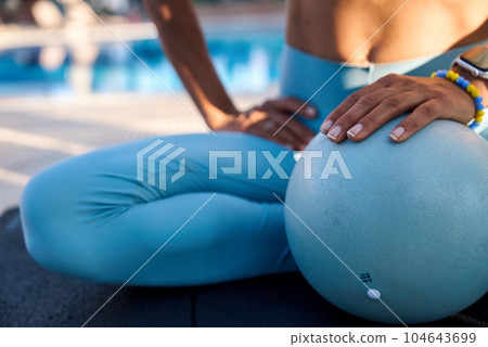 Caucasian girl doing pilates with special equipment outdoor. Workout, yoga, balance, concentration 104643699