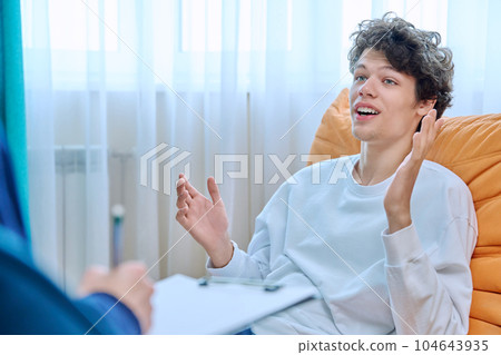 Young male college student in therapy session with psychologist Young male college student in therapy session with psychologist 104643935