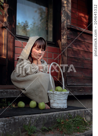 Dreaming girl with apples on a summer evening near the old house. Dreaming girl with apples on a summer evening near the old house. 104645312