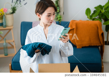A young woman who buys and sells clothes by mail order business image A young woman who buys and sells clothes by mail order business image 104645381