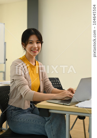 Portrait of pretty young asian woman using laptop, working on design project at modern office 104645504