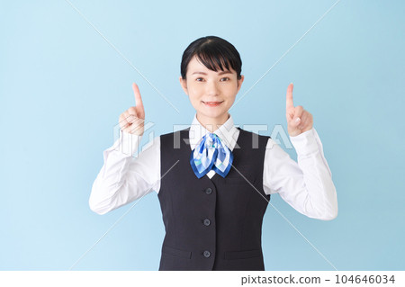 一位從事接待工作和文書工作的女性，穿著絲帶領帶制服，背心上用手指指著 104646034