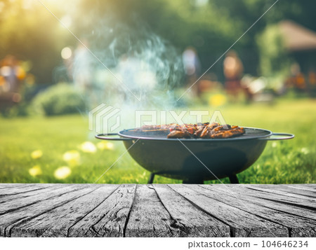 summer time in backyard garden with grill BBQ, wooden table, blurred background summer time in backyard garden with grill BBQ, wooden table, blurred background 104646234