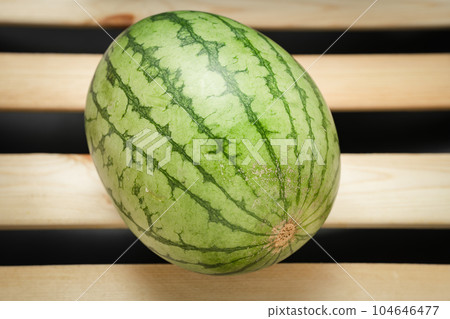 The watermelon placed on a wooden board. The watermelon placed on a wooden board. 104646477