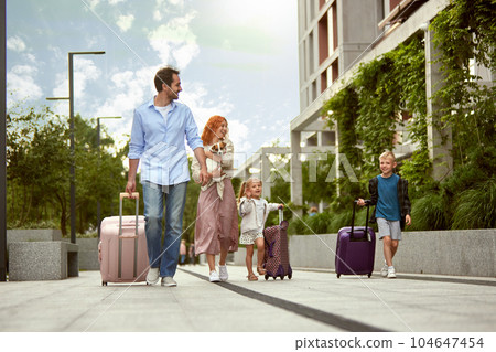 Young happy family, man and woman, parents going on vacation with little boy, girl and dog. Family trip. Warm summer day 104647454