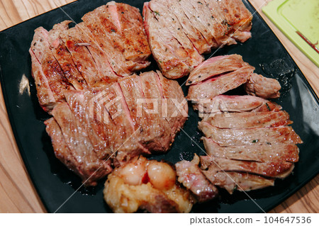 Beef steak with greens on a black plate. Steak with Basil cooked in the culinary master class 104647536