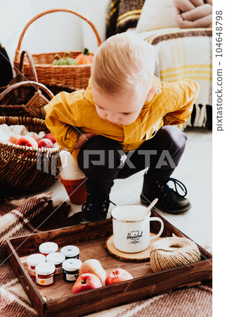 Cool trendy hipster boy 2 years old wears yellow jacket posing at the decorated photozone of autumn decor with beautiful bright autumn leaves. Cool trendy hipster boy 2 years old wears yellow jacket posing at the decorated photozone of autumn decor with beautiful bright autumn leaves. 104648798